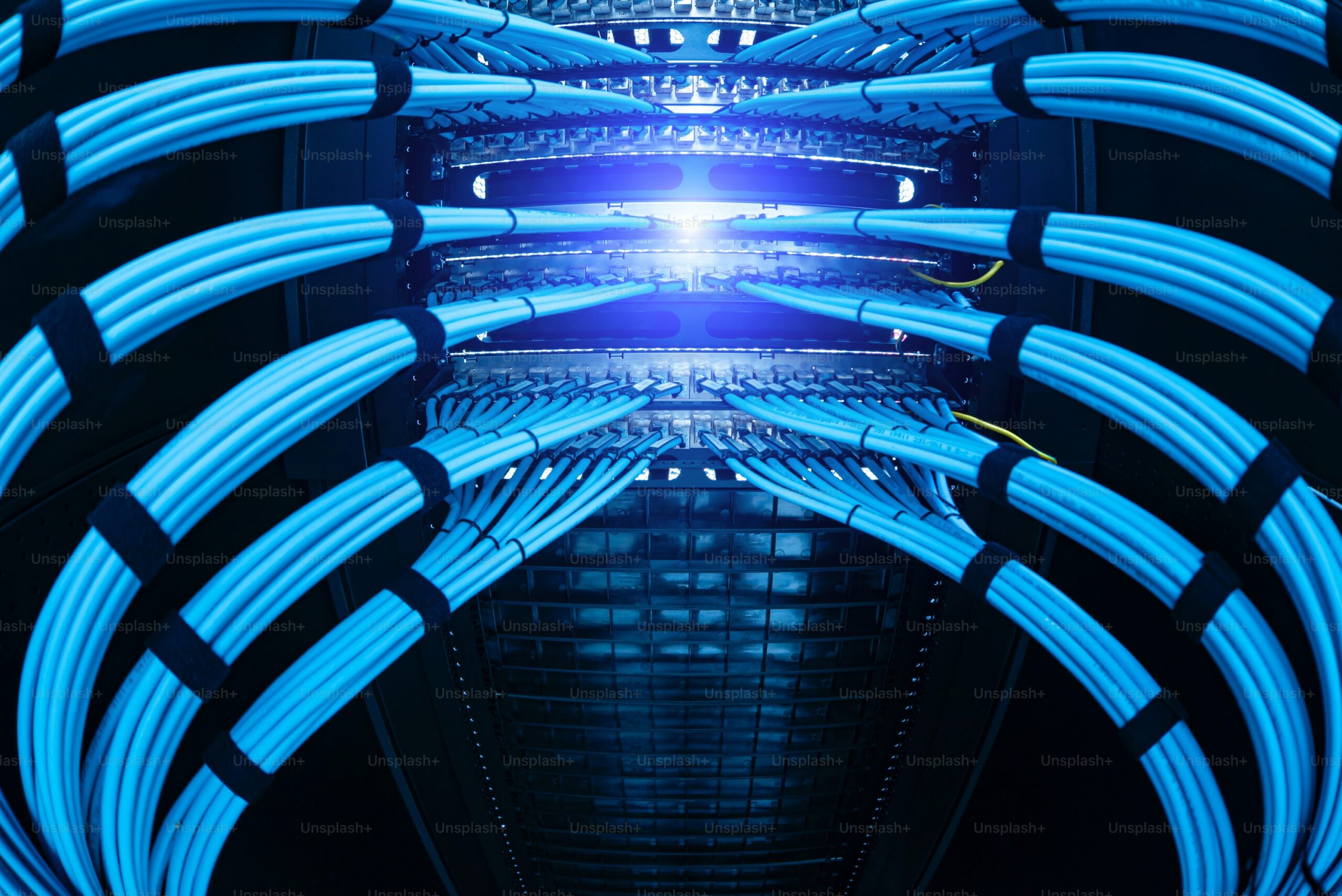 Vibrant blue Ethernet cables neatly arranged in a modern server rack showing connectivity for Kubernetes networking architecture